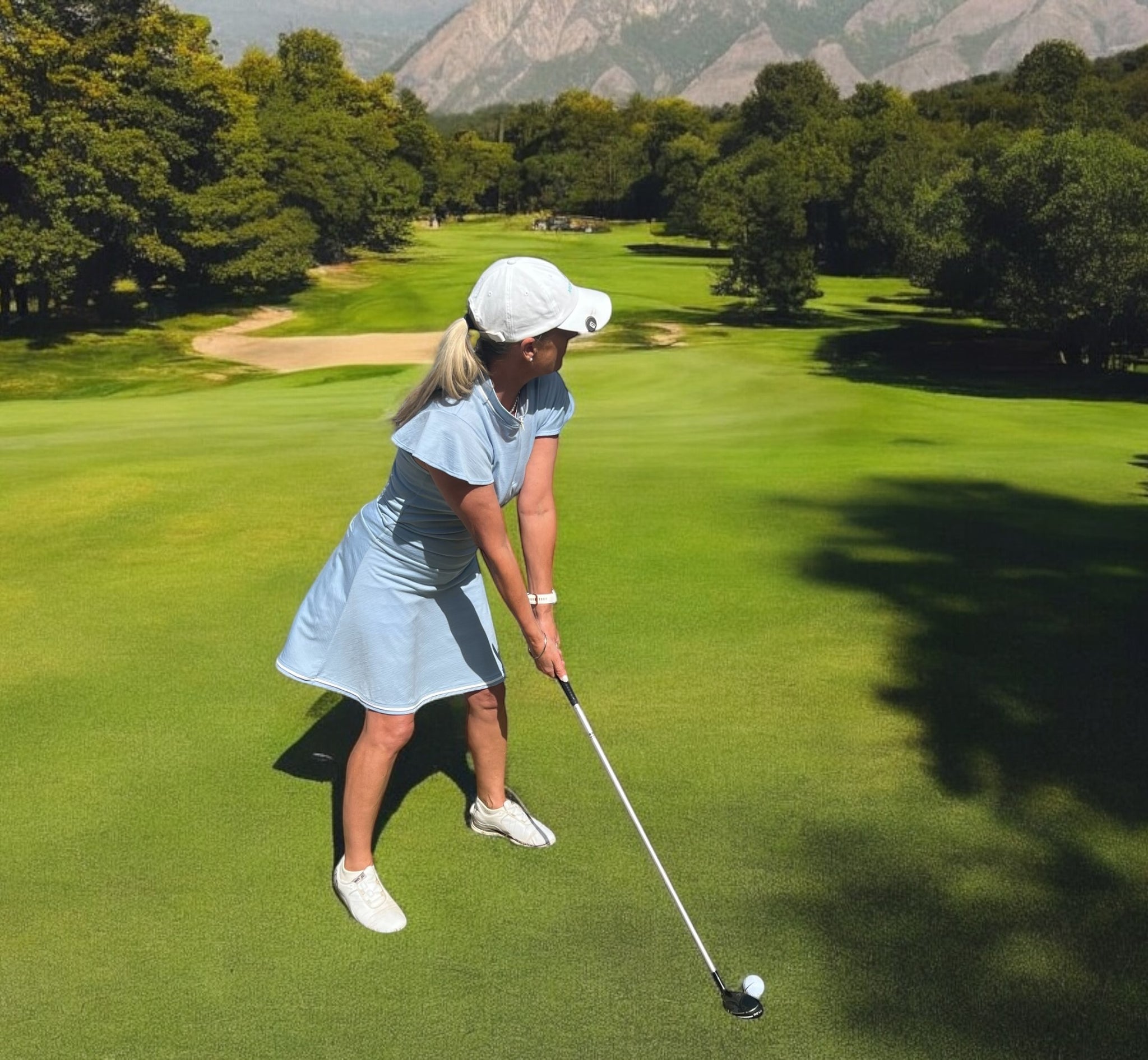 Ladies Merino Golf Skirt - Ice Blue worn by female golfer on green course in sunny outdoor setting.